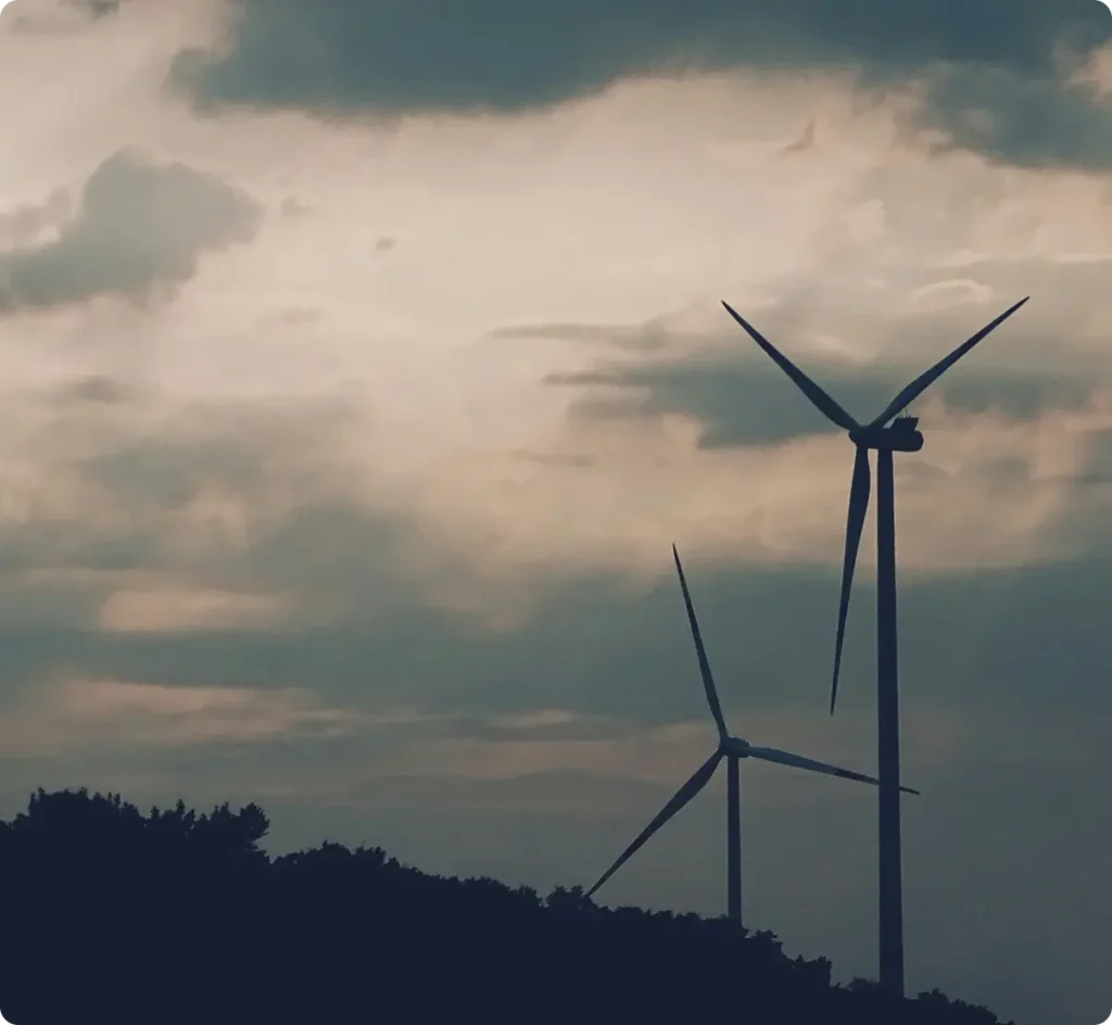 Two windmills with a cloudy sky
